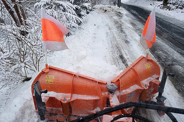 Sicht aus der Fahrerkabine eines Winterdiens-Fahrzeugs auf den Schneepflug